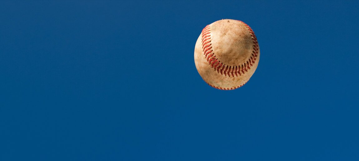 a baseball in the sky aftering being hit with a fungo bat